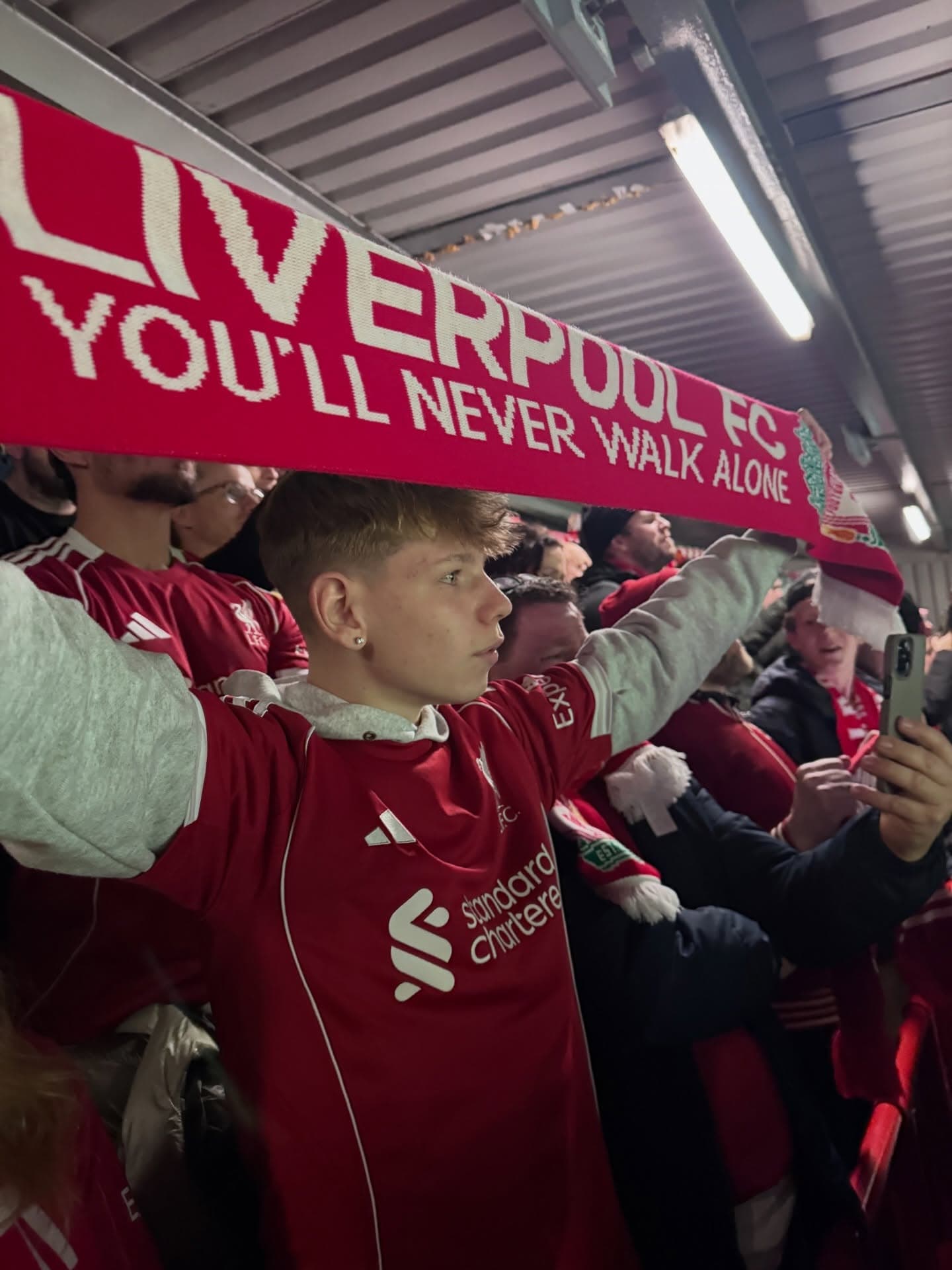 Liverpool-fan med 'You'll Never Walk Alone'-tørklæde på stadion